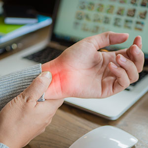 A person gripping their wrist, indicating a personal injury - Leonard Law Firm