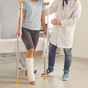 A man with a leg cast stands beside a doctor, highlighting her personal injury - Leonard Law Firm