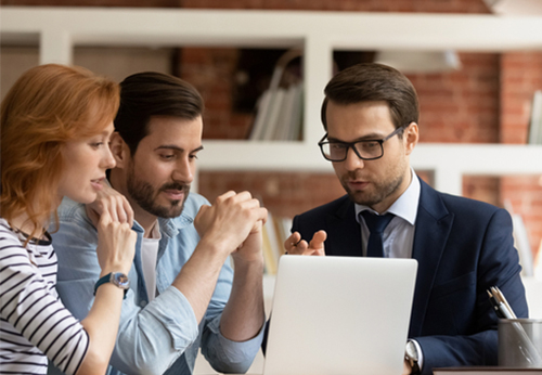 Three professionals reviewing information on a laptop, emphasizing legal services for businesses
