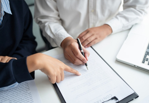 Two people signing or reviewing a legal contract, representing the Leonard Law Firm's personalized service