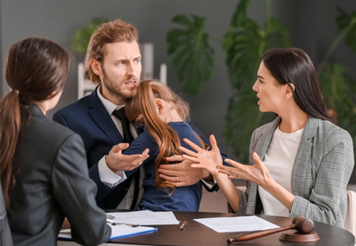 Divorcing couple arguing while a child is held by one parent, representing the choice for an uncontested divorce in Pope County, IL