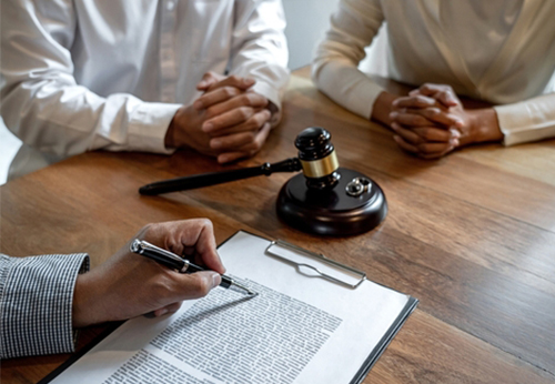 Lawyer assisting a couple signing uncontested divorce paperwork with a gavel on the table in Pope County, IL